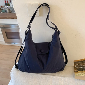 Detail of navy nylon tote bag showing adjustable straps and waterproof texture