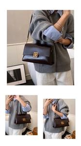 Détail du sac à bandoulière en cuir marron foncé avec une boucle carrée dorée chic