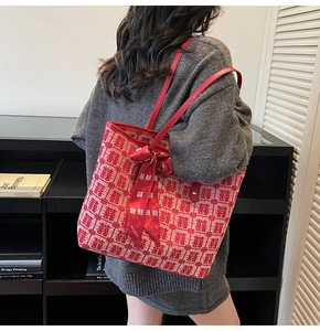 Detail of red tote bag featuring festive double happiness jacquard and silk bow charm