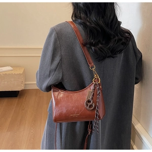 Borsa a tracolla a mezzaluna in pelle marrone con tracolla regolabile e nappa