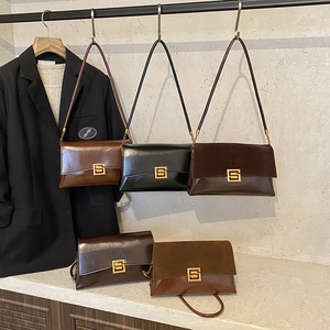 Vue détaillée des sacs à main en cuir mat et lisse avec boucle dorée élégante en forme de S