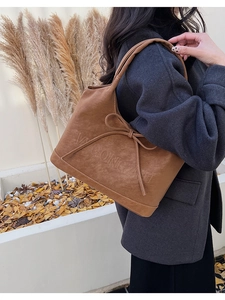 Detail einer braunen Vintage Schleife Tragetasche am Modell in herbstlicher Umgebung