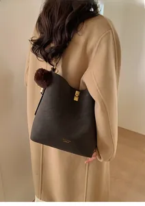 Détail du sac seau marron vintage avec fermoir doré et pendentif en peluche doux