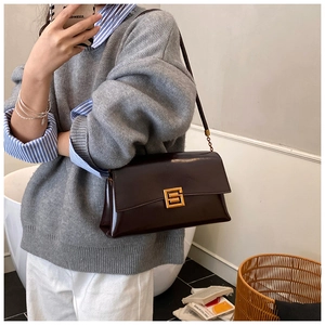 Détail du sac bandoulière en cuir verni bordeaux avec boucle en métal doré carré