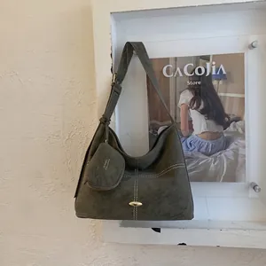Macro detail of dark green tote bag featuring white stitching and mini zipper pouch accessory