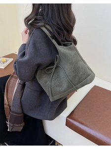 Detail of vintage dark green frosted suede tote bag with elegant bow and embossed lettering