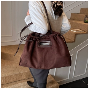 Détail du sac cabas en daim marron foncé avec cordon de serrage et poignée découpée