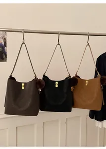 Détail de sacs seaux mats avec pompon en peluche et logo embossé en trois coloris