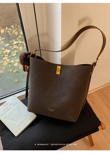 Détail d'un sac seau vintage marron givré avec fermoir doré et pendentif en peluche