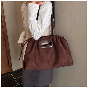 Détail du sac cabas en daim marron foncé avec cordon de serrage et poignée découpée