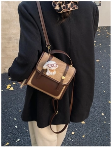 Détail du sac à dos en daim bicolore avec un pendentif chien en peluche sur un mannequin