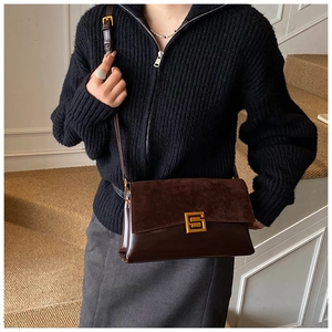Détail d'un sac bandoulière marron foncé en mélange de daim et de cuir lisse vintage