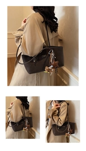 Detail view of large dark brown frosted leather tote bag with star and bear charm pendants