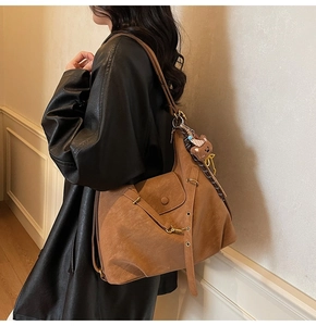 Detail of suede leopard print tote bag with bear charm and decorative silk scarf