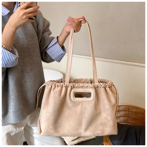 Vue détaillée du sac cabas en daim beige avec fermeture à cordon et poignée rectangulaire