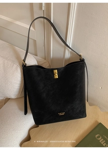 Gros plan du sac seau noir givré avec un fermoir rotatif en métal doré élégant