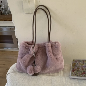 Dettaglio della trama della borsa a secchiello in peluche rosa con pelliccia e cinturini