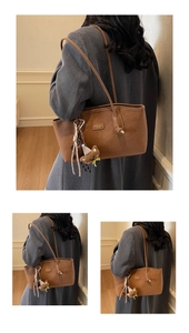 Detailed close-up of brown matte faux leather tote bag with a cute plush bear charm