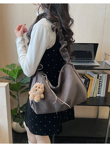 Detail of coffee brown ruched cloud tote bag with cute plush bear charm on strap