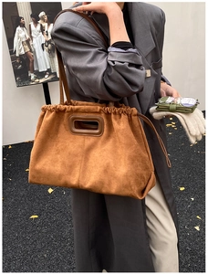 Détail du sac cabas en daim marron avec cordon de serrage et texture mate élégante