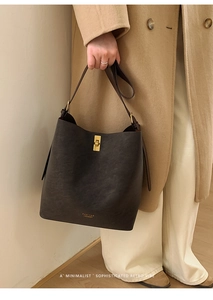 Vue détaillée du sac seau en cuir marron mat avec boucle dorée et logo gravé