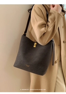Détail du sac seau rétro avec fermoir rotatif doré et texture en cuir grainé élégant