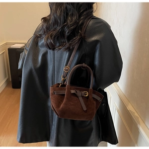 Borsa a mano in pelle scamosciata marrone scuro con dettagli in bronzo e cappotto nero