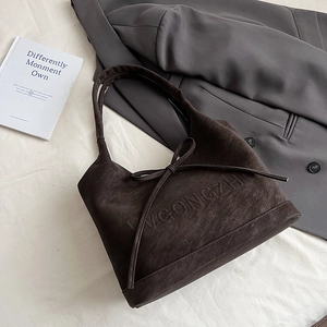 Detailansicht der dunkelbraunen Tragetasche aus Mattleder mit eleganter Schleife