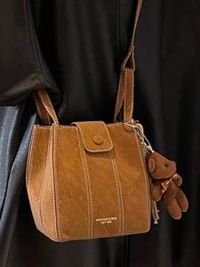 Sac seau marron avec surpiqûres blanches et pendentif décoratif en forme d'ours