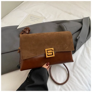 Détail du sac en daim marron foncé et cuir lisse avec une boucle métallique dorée