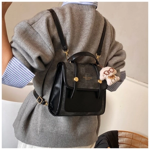 Gros plan d'un sac à dos en daim avec lettrage ZSKE et breloque chiot en peluche
