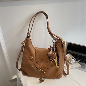 Brown retro suede tote bag detail with snap closure and cute teddy bear charm pendant