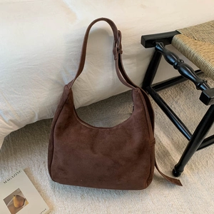 Détail du sac hobo en daim marron foncé avec boucle réglable et fermeture à glissière