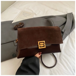 Détails du sac bandoulière en daim et cuir marron avec une boucle géométrique dorée