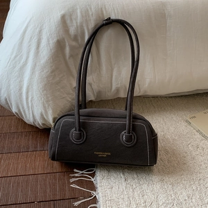 Detail view of charcoal suede shoulder bag with contrast white stitching and gold logo