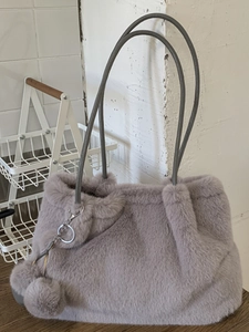 Borsa a secchiello minimalista in ecopelliccia grigia con tracolla e pompon invernale
