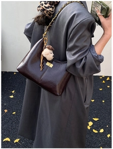 Dark coffee crescent shoulder bag with gold twist lock and chain strap on a model
