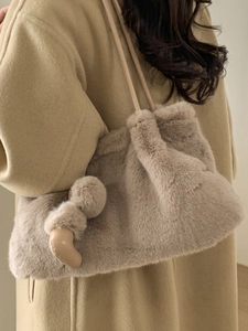 Borsa a secchiello minimalista in peluche beige da donna in morbida ecopelliccia con pompon