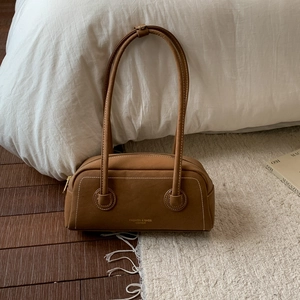 Detailed close-up of brown suede hobo bag featuring white contrast stitching and gold logo