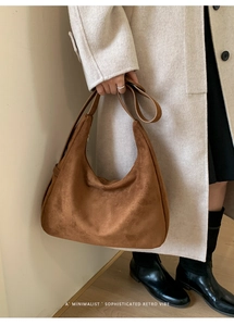 Détail du sac hobo marron en daim au style rétro minimaliste pour femmes