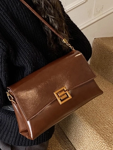 Sac bandoulière en cuir marron givré avec boucle dorée dans un style chic minimaliste