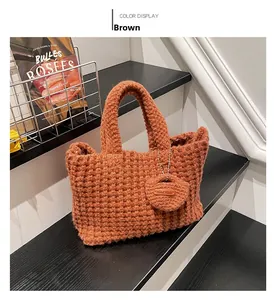 Detail of a brown handmade knit tote bag showing thick texture and leather tag