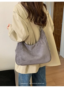 Sac fourre-tout minimaliste en daim gris porté par un mannequin pour un style rétro