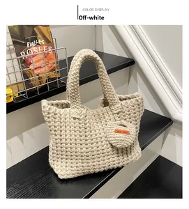 Detail of hand-woven cream tote bag featuring a round charm and handmade leather label