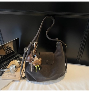 Detailansicht der kaffeebraunen Hobo-Tasche mit Vintage-Ledertextur und Bären-Anhänger