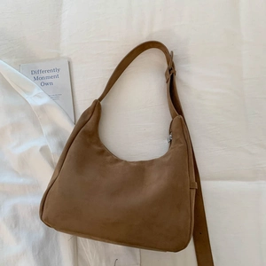 Détail du sac fourre-tout demi-lune en daim marron avec bandoulière réglable et fermeture