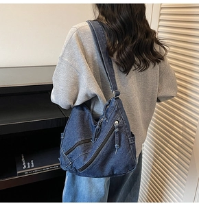 Vue arrière du mannequin portant un grand sac à bandoulière en denim lavé multi-poches