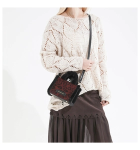 Détail du sac bandoulière léopard rouge avec bordure en fausse fourrure noire et plaque