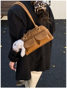 Brown suede shoulder bag with dual front pockets and a cute plush rabbit pendant detail