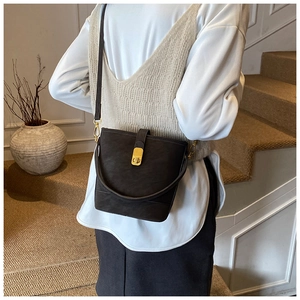 Detailaufnahme der braunen Bucket-Bag mit goldenem Metallverschluss und Ledertextur